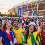 Football supporters preparing to attend a FIFA World Cup match with stadium seating and a match-day atmosphere in the background.